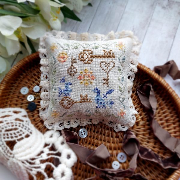 This is pattern PDF pincushion in a primitive style. There are blue birds and old keys on the pattern. Sample size approximately 3.56 x 3.56 inches (9 x 9 cm), embroidered on 32 count fabric.