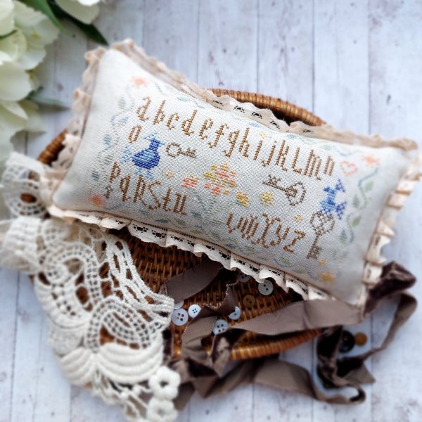 This is pattern PDF pincushion in a primitive style. There are Alphabet, blue birds and old keys on the pattern.