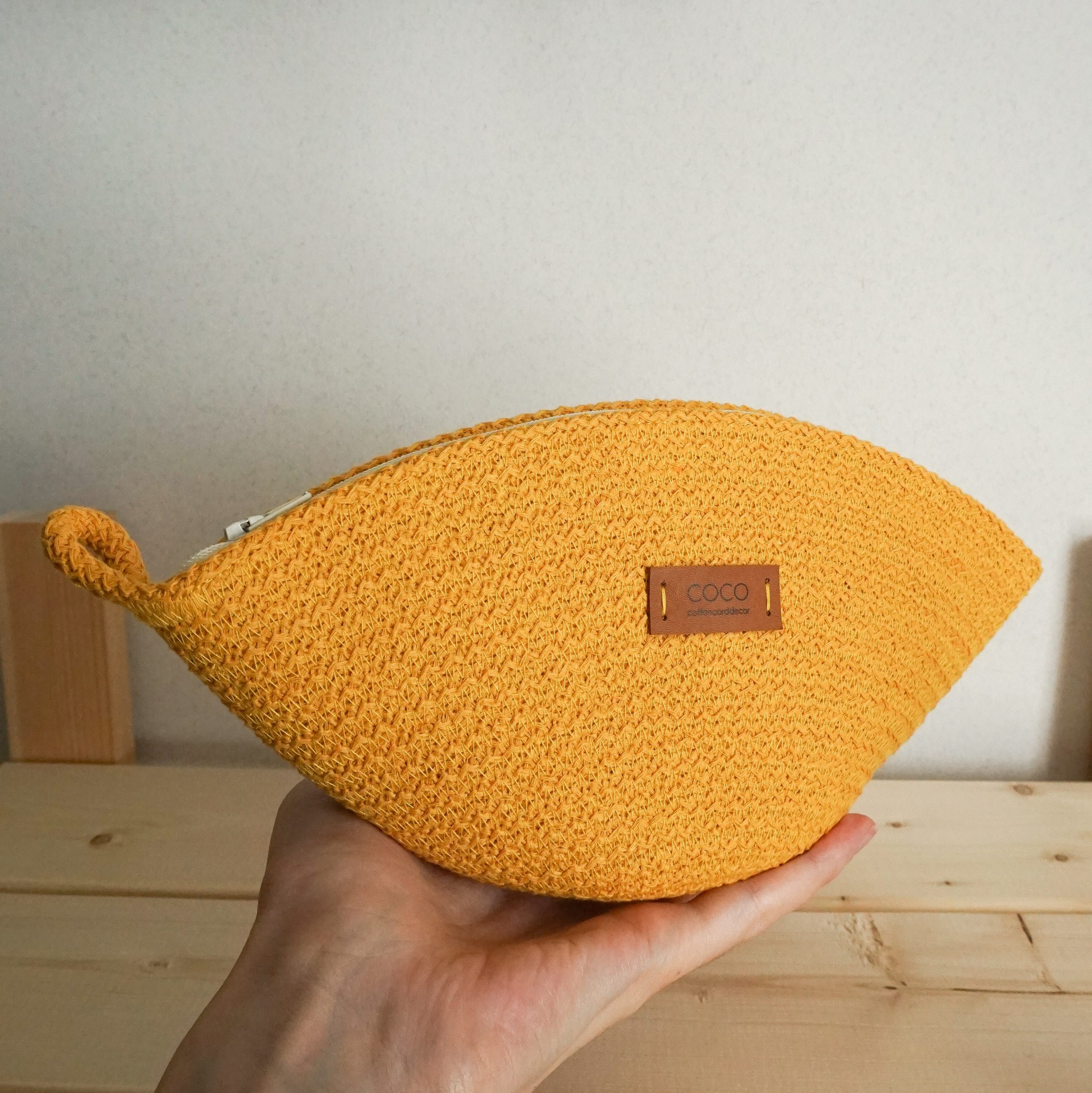 yellow soft rope cosmetic bag in hand