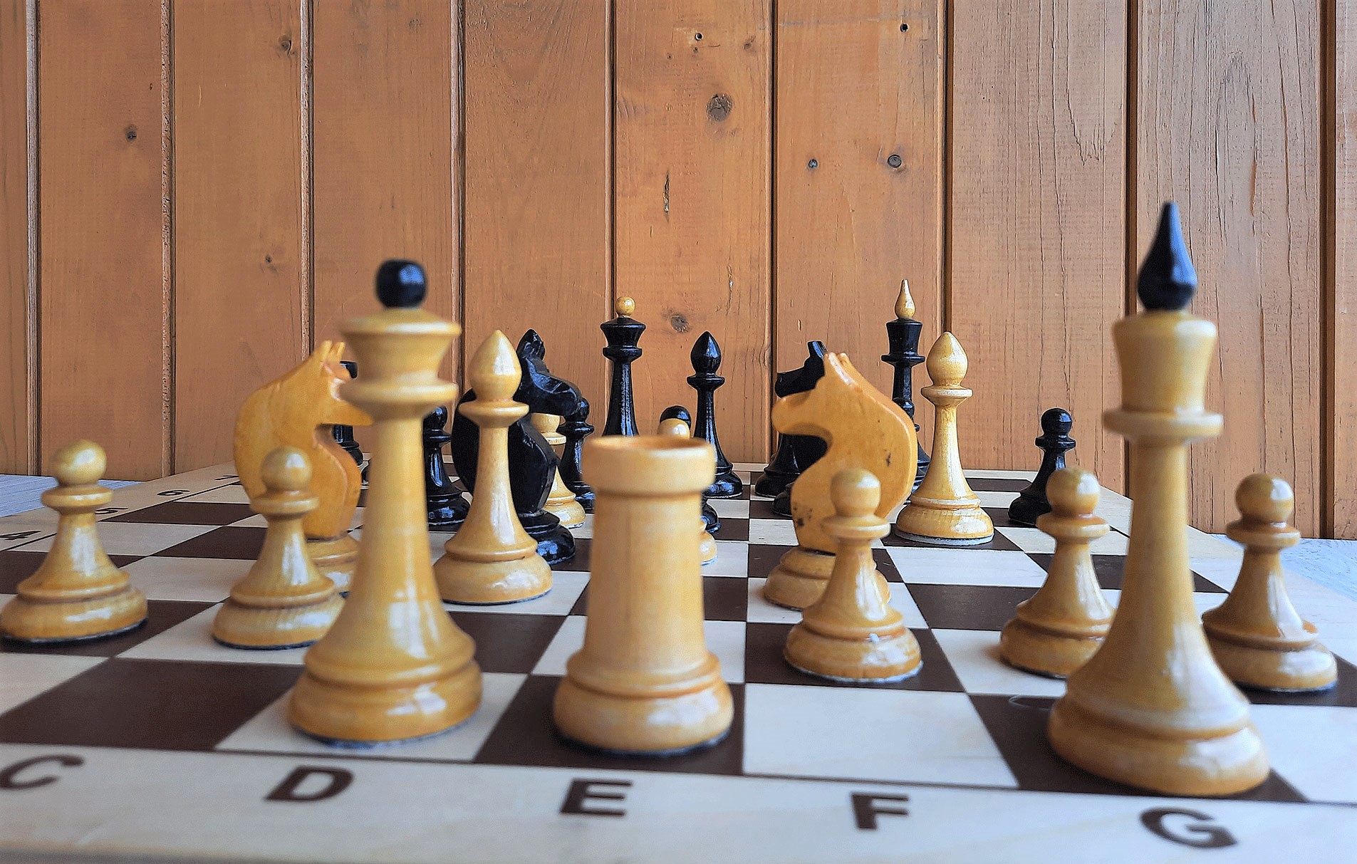 Vintage wooden chess set with queen gambit opening, close-up view