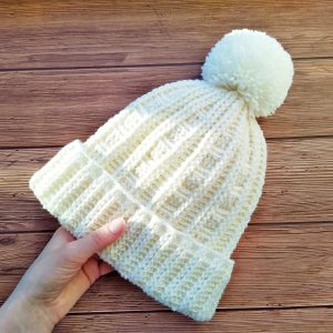 Crochet hat ribbing pattern a double brim for beginners. The beanie can be made in a women's size Small and Medium. Instructions for making the pom pom included. The tutorial contains US and UK crochet terms. Hat beanie are crocheted in the round without sewing with a needle.