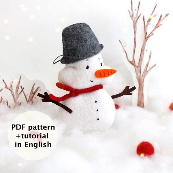 Felt toy Snowman with the pail on the head near the snow and drawing winter trees