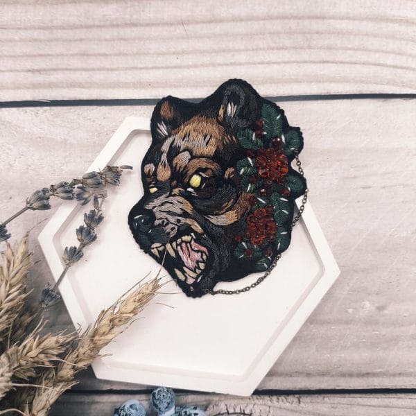 Brooch Bear with berries is embroidered with threads, berries are made of glass beads, decor is a metal chain. Front view