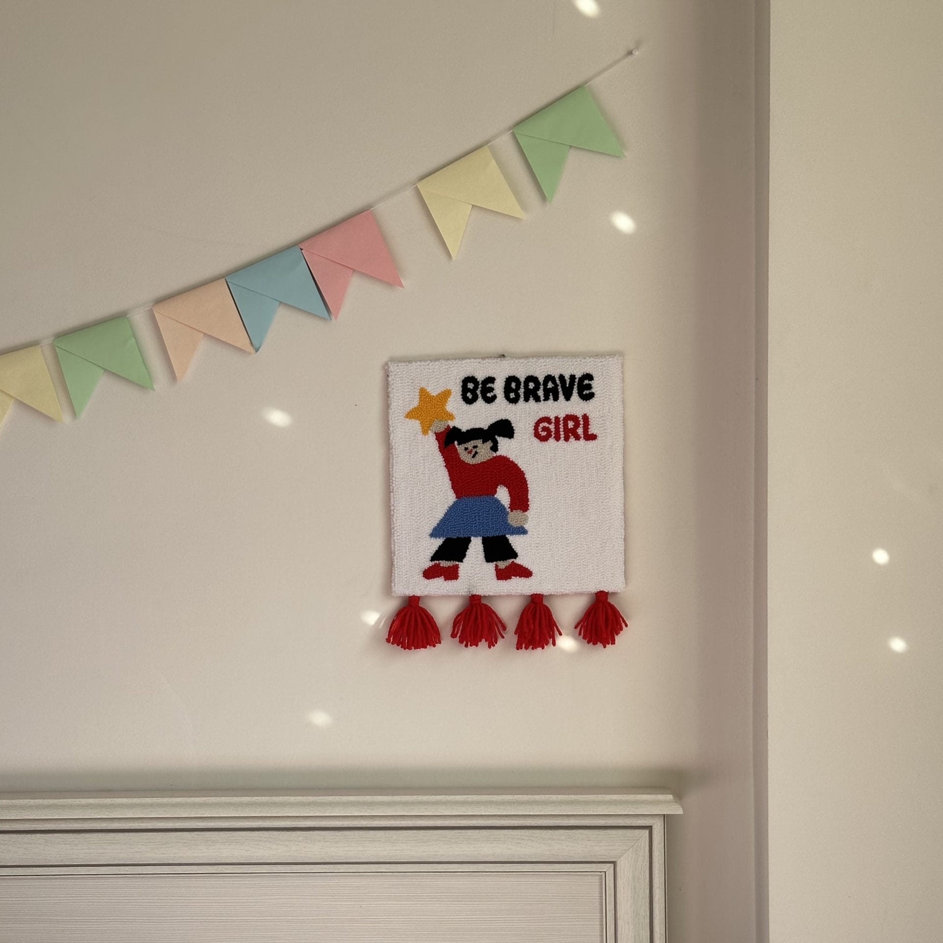 Punch Needle Wall Hanging “Be Brave Girl” Handmade Textile Art 8 Handmade “Be Brave Girl” punch needle wall hanging displayed above bed in cozy bedroom